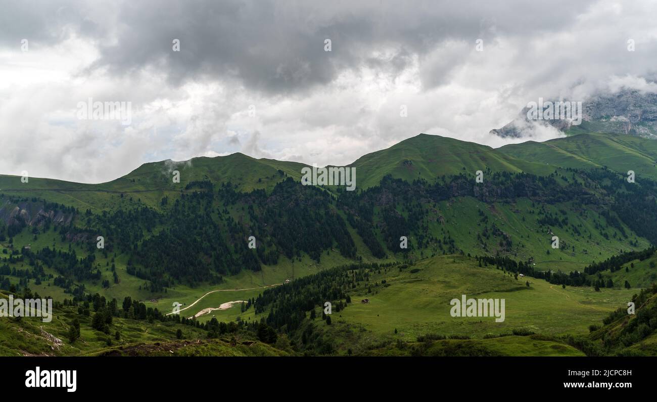 Val Duron con le colline ricoperte di erba sopra nelle Dolomiti duellando per lo più nuvoloso giorno d'estate Foto Stock