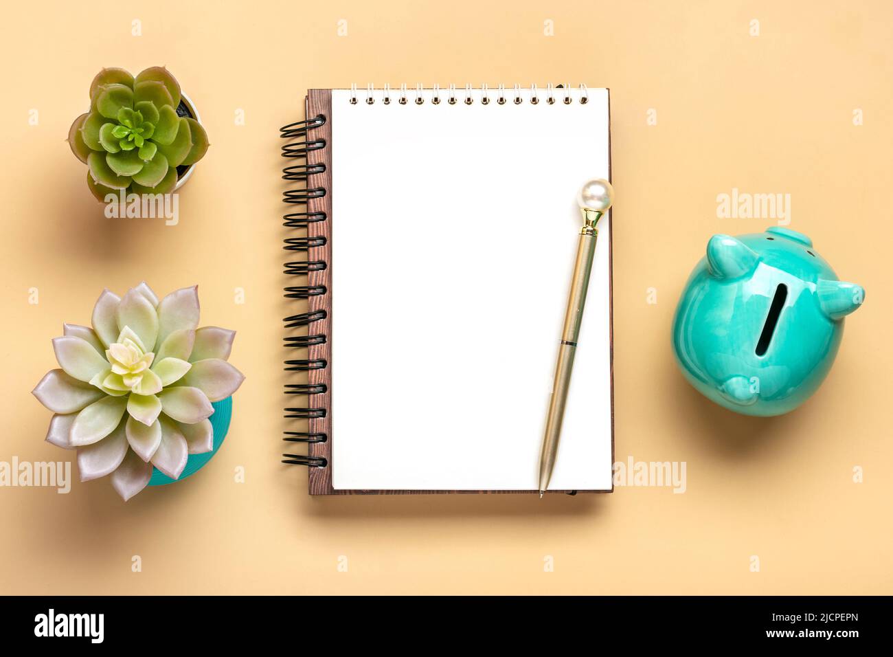 Notepad, Piggy bank, home plant, calcolatrice, penna su sfondo beige Pianificazione finanziaria, obiettivi, progetto per il nuovo anno concetto Top view Flat Lay Finance formazione e strategie Copy space Mock up. Foto Stock