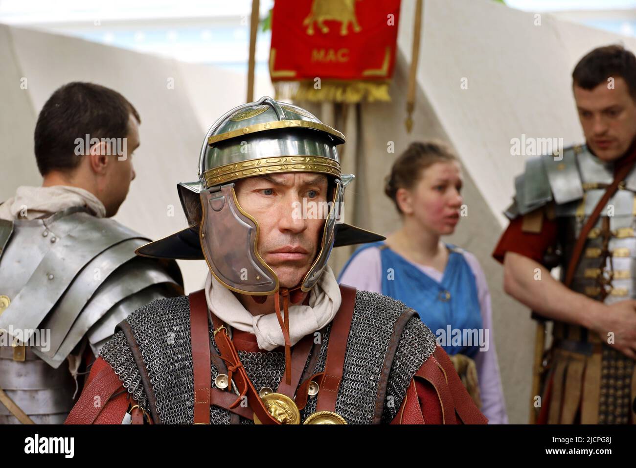 Soldato di una Legione romana con legionari sullo sfondo durante i periodi storici delle feste e delle epoche. Legionario nel campo, esercito dell'antica Roma Foto Stock