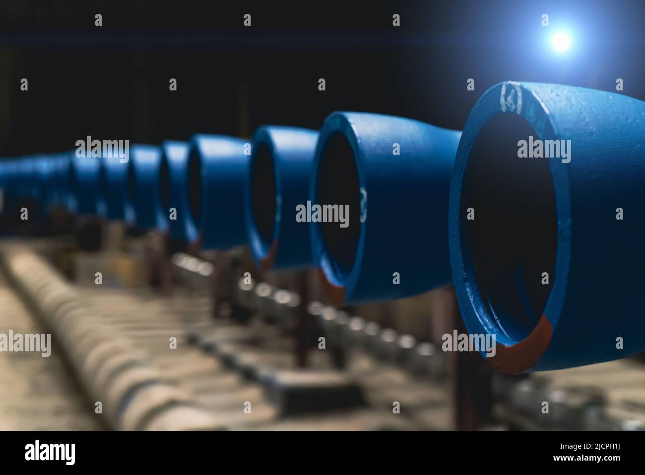 Gruppo di tubi in metallo blu per l'acqua nei magazzini di fabbriche metallurgiche. Foto Stock