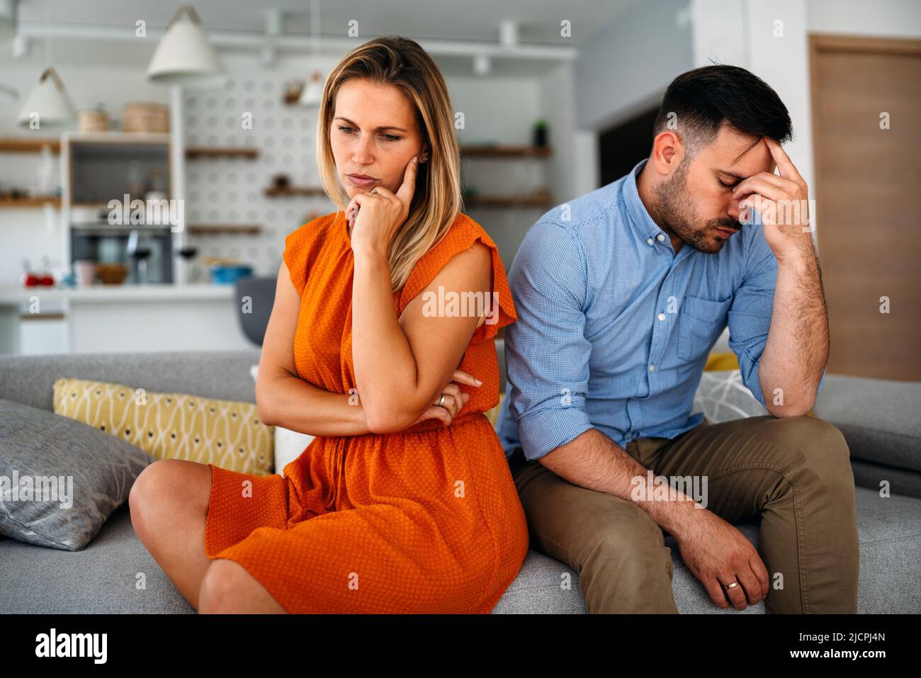 Triste coppia pensiva pensando a problemi di relazioni seduta sul divano, conflitti nel matrimonio. Foto Stock