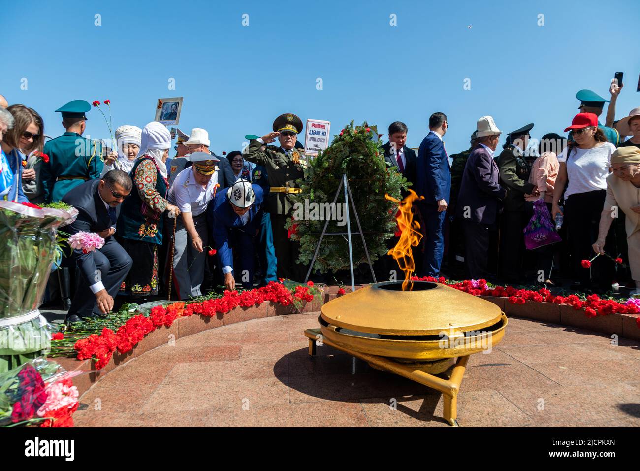 Bishkek, Kirghizistan - 9 maggio 2022: Persone che mettono i garofani alla fiamma eterna il 9 maggio giorno della Vittoria Foto Stock