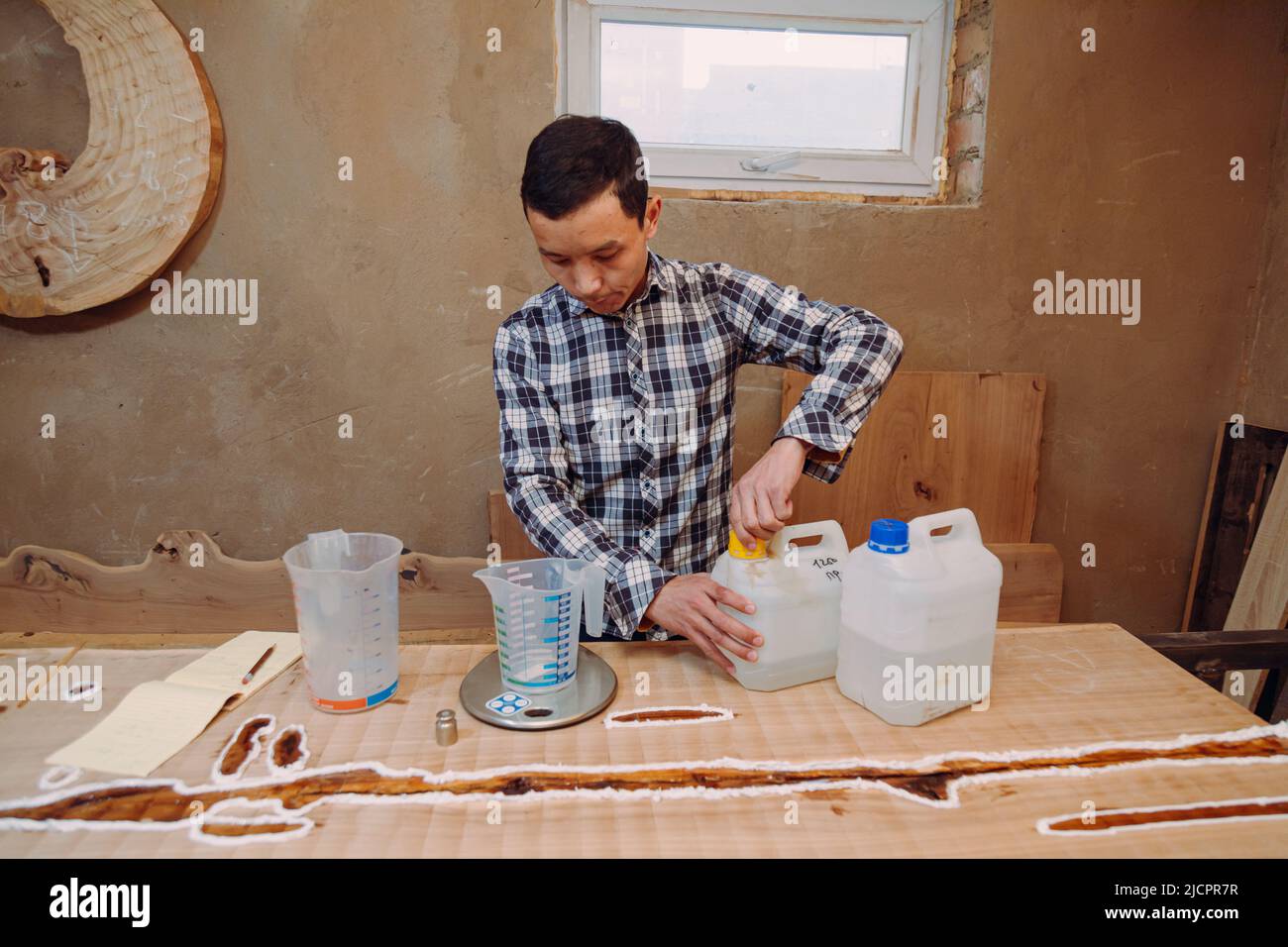 Carpentiere preparazione resina epossidica. Processo di fabbricazione di una resina artigianale e tavola di legno. Foto Stock