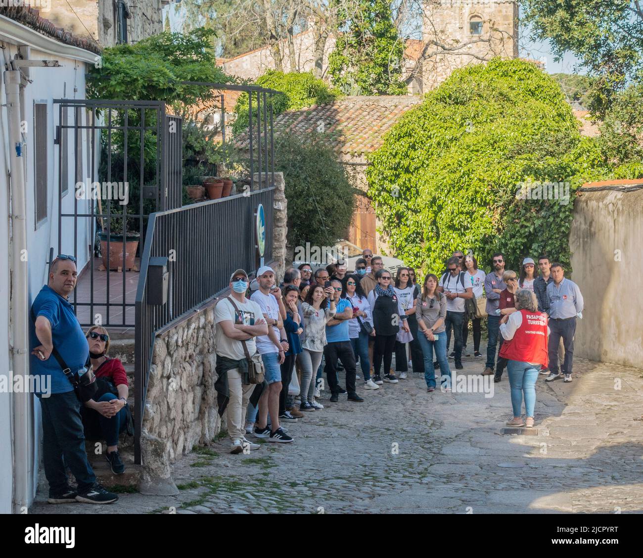 Una guida turistica che interpreta la città medievale di Trujillo, Extramadura, Spagna in un gruppo di turisti. Foto Stock