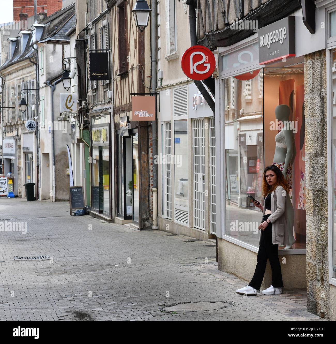 Donna che fuma fuori negozio Foto Stock