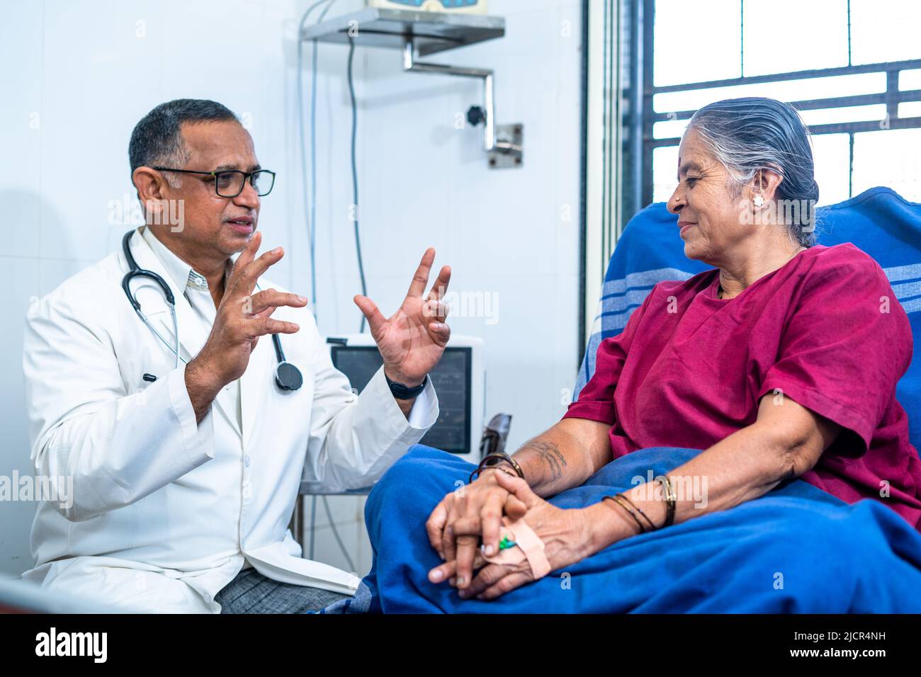 Medico vicino letto del paziente che consiglia alla donna anziana all'ospedale - concetto di diagnosi, costruzione di fiducia e malattia mentale. Foto Stock