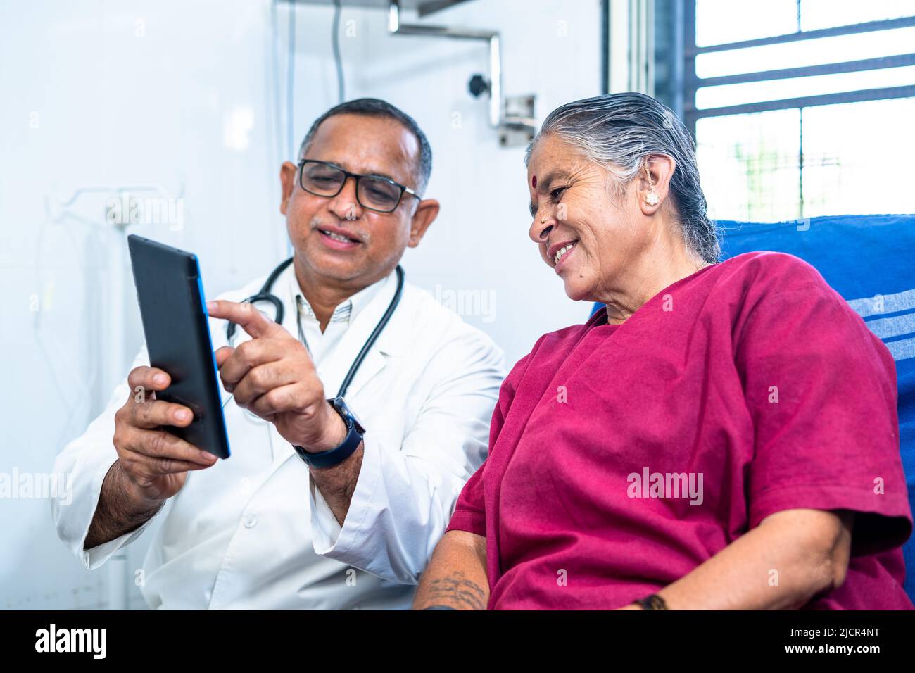 Medico che spiega da tab a senior pateint circa la condizione di salute dopo l'intervento chirurgico - concetto di tecnologia, assistenza sanitaria e relax. Foto Stock