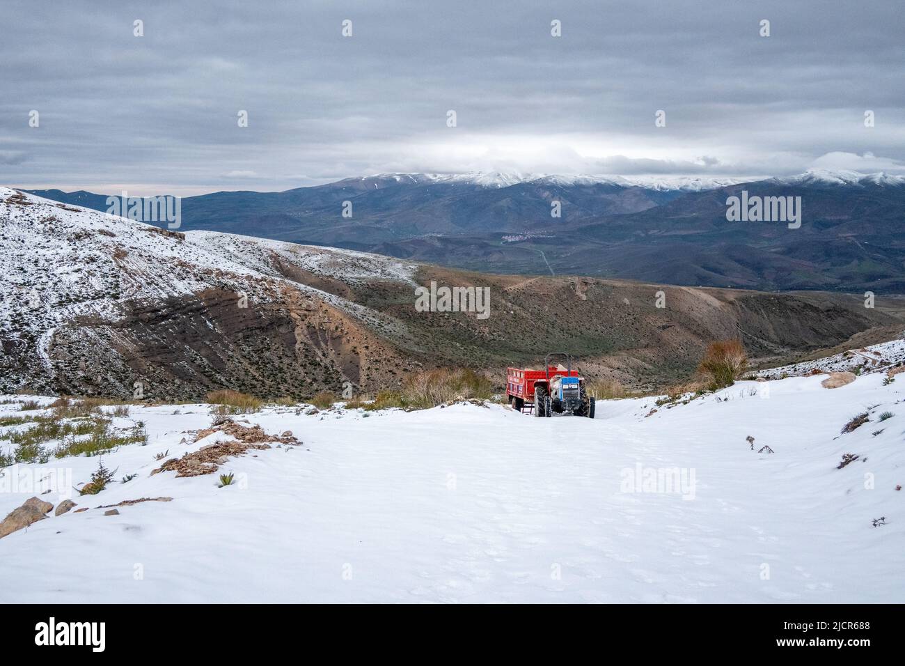 Un trattore sulle montagne innevate del Taurus. Niğde, Türkiye. Foto Stock