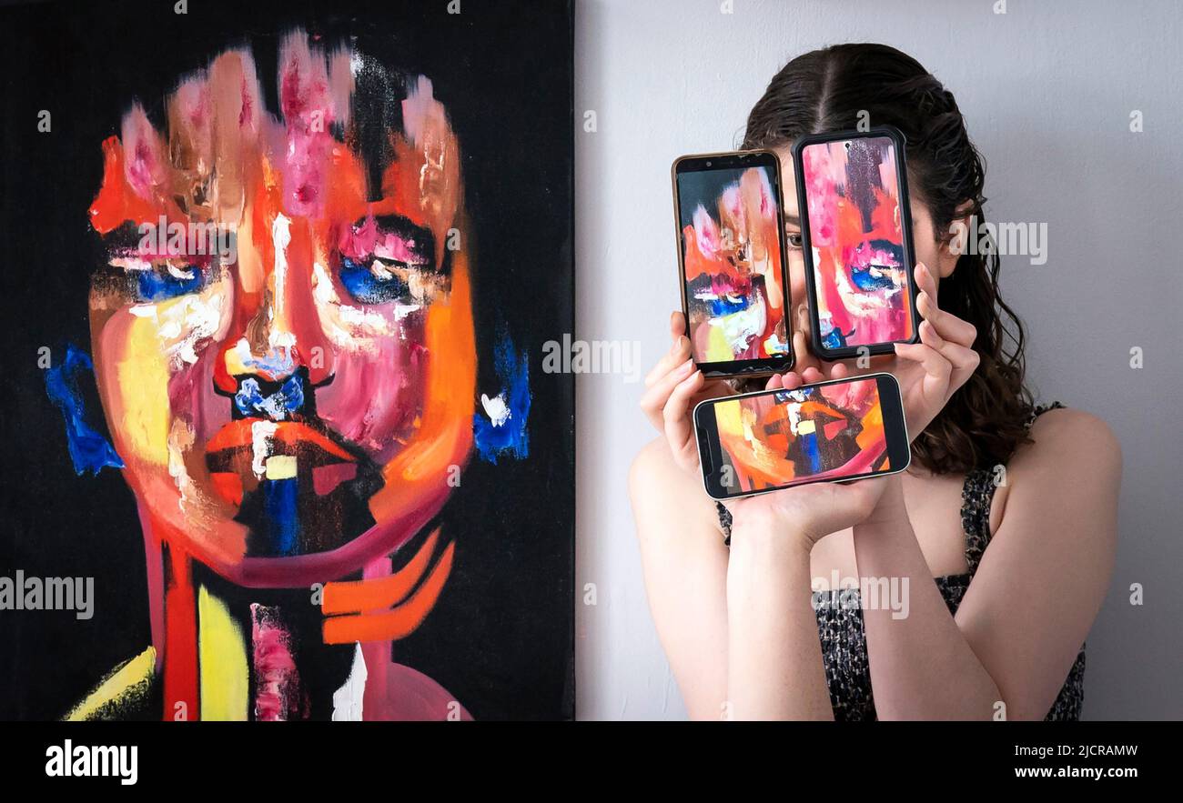 Il curatore Florence Kitching, è raffigurato con un'opera d'arte intitolata 'Respondent' dell'artista Ruby Dice, insieme ai telefoni cellulari che mostrano fotografie dell'opera dell'artista, durante una fotocall per lanciare la mostra di laurea in Belle Arti all'Università di Leeds. Data foto: Mercoledì 15 giugno 2022. La mostra di laurea di quest'anno celebra il lavoro di 62 studenti laureati, che spaziano attraverso tutti i mezzi dell'arte contemporanea Foto Stock