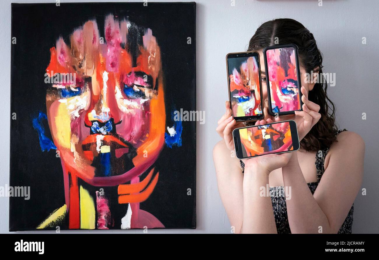 Il curatore Florence Kitching, è raffigurato con un'opera d'arte intitolata 'Respondent' dell'artista Ruby Dice, insieme ai telefoni cellulari che mostrano fotografie dell'opera dell'artista, durante una fotocall per lanciare la mostra di laurea in Belle Arti all'Università di Leeds. Data foto: Mercoledì 15 giugno 2022. La mostra di laurea di quest'anno celebra il lavoro di 62 studenti laureati, che spaziano attraverso tutti i mezzi dell'arte contemporanea Foto Stock