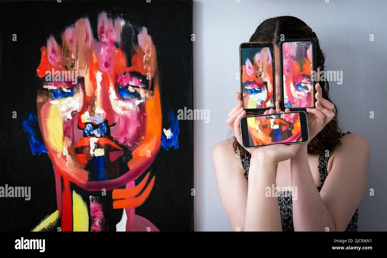 Il curatore Florence Kitching, è raffigurato con un'opera d'arte intitolata 'Respondent' dell'artista Ruby Dice, insieme ai telefoni cellulari che mostrano fotografie dell'opera dell'artista, durante una fotocall per lanciare la mostra di laurea in Belle Arti all'Università di Leeds. Data foto: Mercoledì 15 giugno 2022. La mostra di laurea di quest'anno celebra il lavoro di 62 studenti laureati, che spaziano attraverso tutti i mezzi dell'arte contemporanea Foto Stock