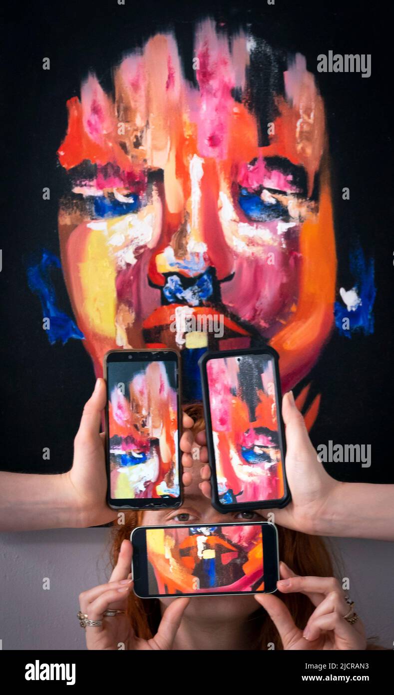 Lo studente Lottie Mac, è raffigurato con un'opera d'arte intitolata 'Respondent' dall'artista Ruby Dice, insieme a telefoni cellulari che mostrano fotografie dell'opera dell'artista, durante una fotocall per lanciare la mostra di fine Art Degree all'Università di Leeds. Data foto: Mercoledì 15 giugno 2022. La mostra di laurea di quest'anno celebra il lavoro di 62 studenti laureati, che spaziano attraverso tutti i mezzi dell'arte contemporanea Foto Stock