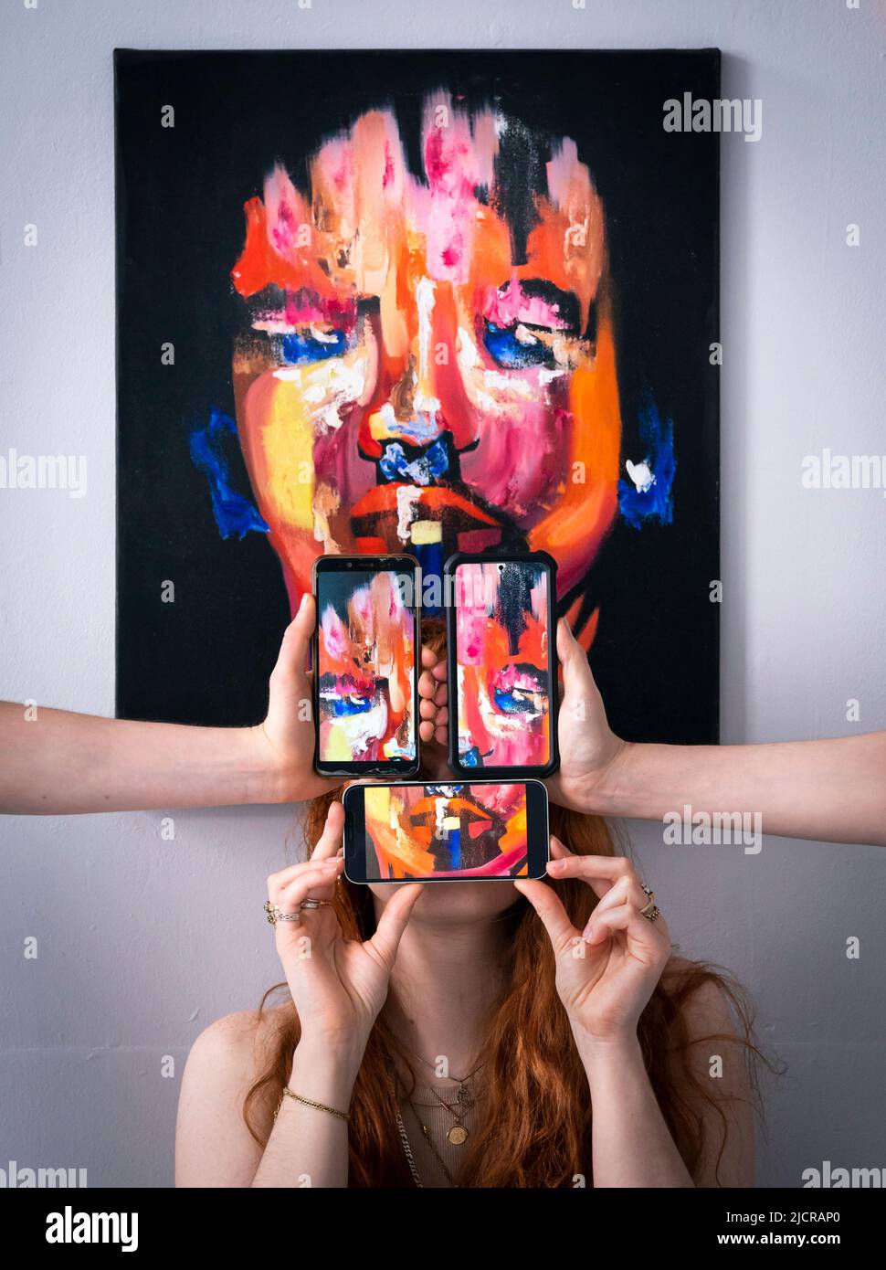 Lo studente Lottie Mac, è raffigurato con un'opera d'arte intitolata 'Respondent' dall'artista Ruby Dice, insieme a telefoni cellulari che mostrano fotografie dell'opera dell'artista, durante una fotocall per lanciare la mostra di fine Art Degree all'Università di Leeds. Data foto: Mercoledì 15 giugno 2022. La mostra di laurea di quest'anno celebra il lavoro di 62 studenti laureati, che spaziano attraverso tutti i mezzi dell'arte contemporanea Foto Stock