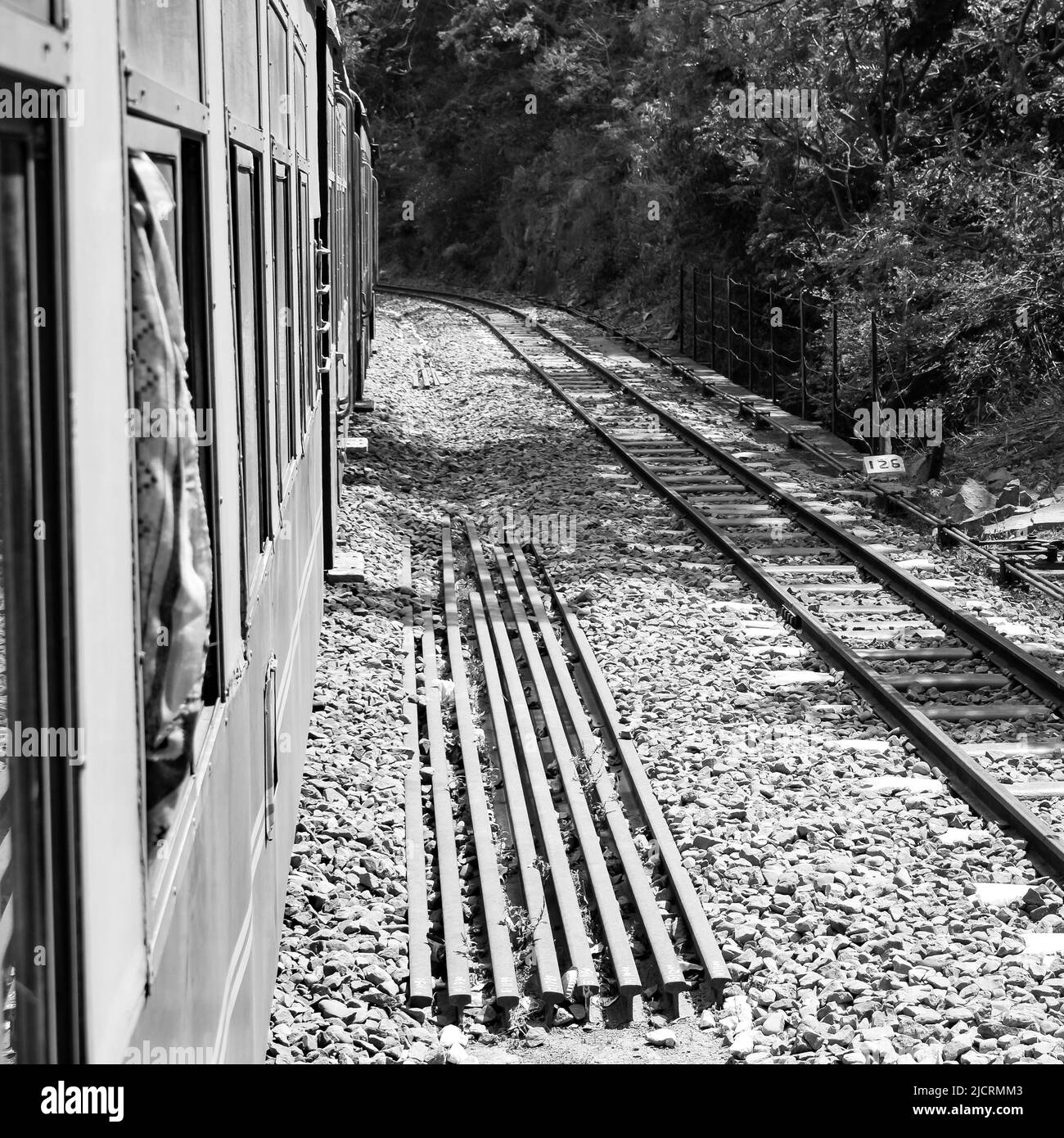 Toy Train in movimento sul pendio di montagna, bella vista, una montagna laterale, una valle laterale che si sposta sulla ferrovia per la collina, tra verde foresta naturale.Toy t Foto Stock