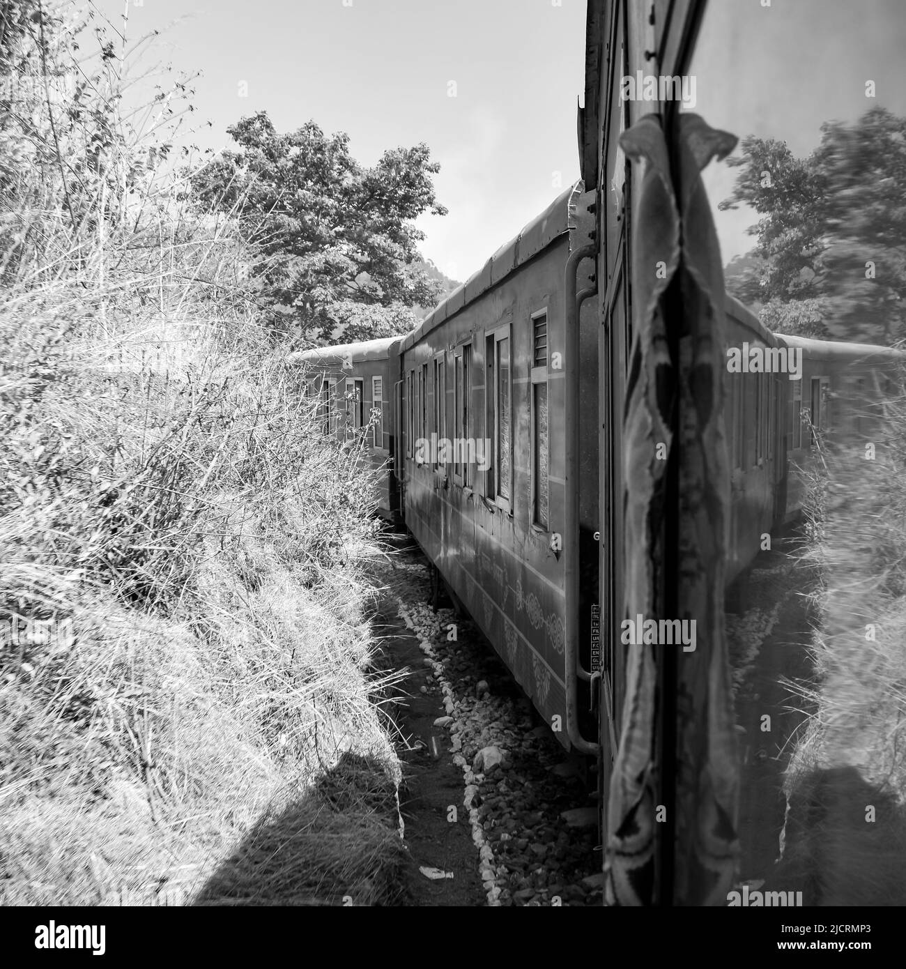 Toy Train in movimento sul pendio di montagna, bella vista, una montagna laterale, una valle laterale che si sposta sulla ferrovia per la collina, tra verde foresta naturale.Toy t Foto Stock