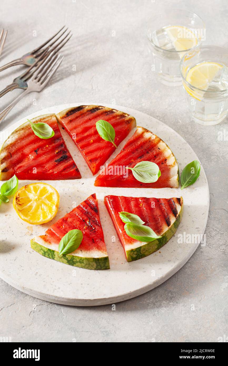 fette di anguria grigliate con limone e basilico. dessert estivo Foto Stock