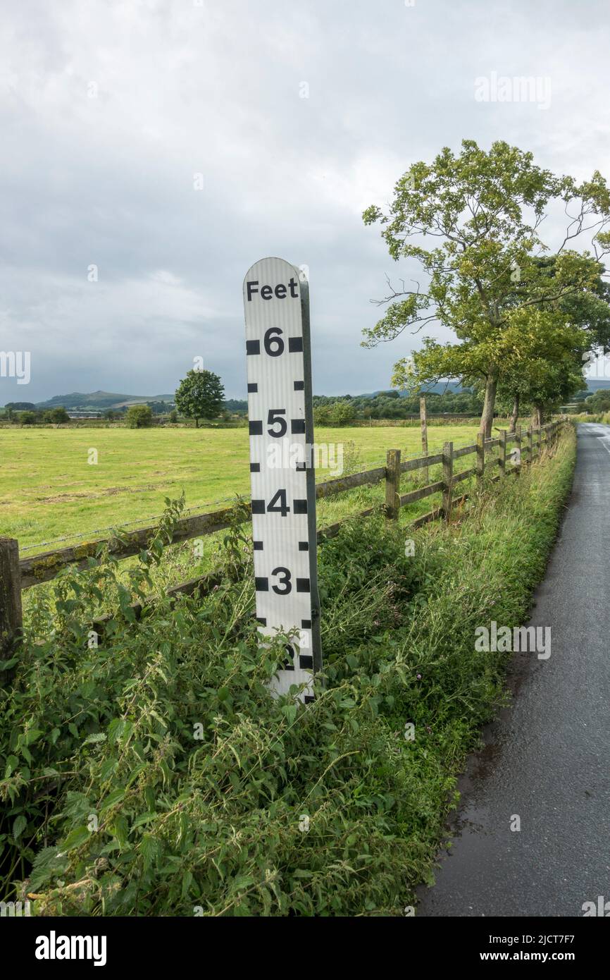 Indicatore di profondità dell'acqua alluvione stradale (che mostra la profondità dell'acqua dei conducenti nell'area) sulla pianura alluvionale del fiume Aire vicino a Skipton, North Yorkshire, Regno Unito. Foto Stock