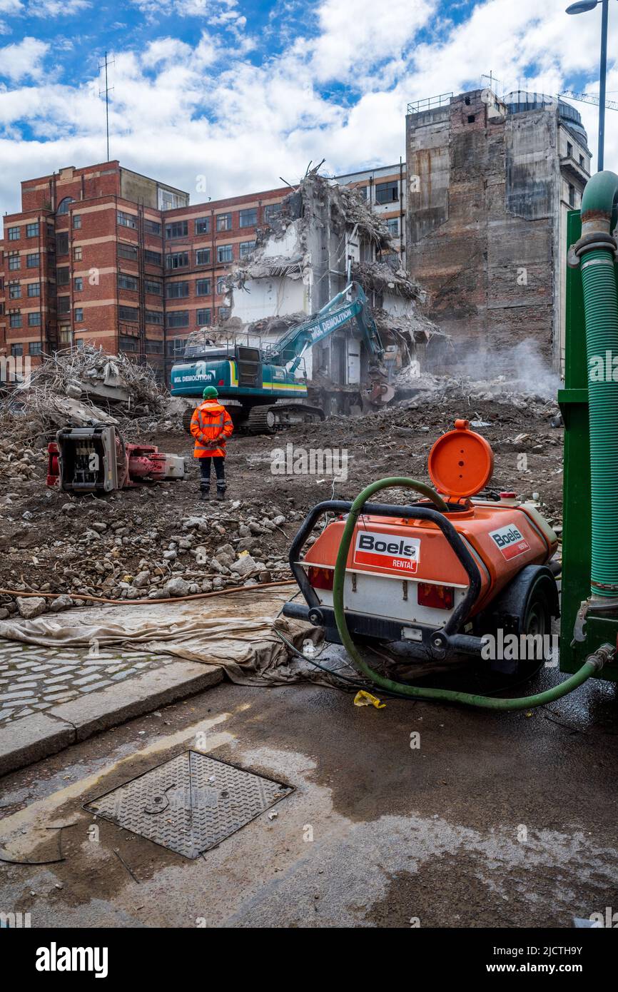 Demolizione di edifici nel centro di Newcastle Regno Unito. L'acqua spruzzata viene utilizzata per eliminare la polvere dall'attività di demolizione. Foto Stock