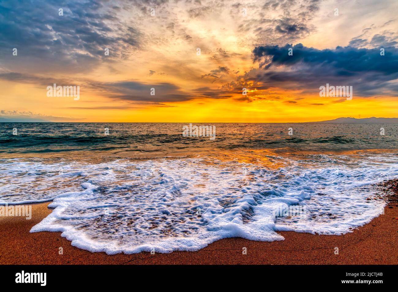 Il Sole si innalza mentre i raggi del Sole si irraggiano in avanti in Un colorato paesaggio tropicale in formato immagine ad alta risoluzione Foto Stock