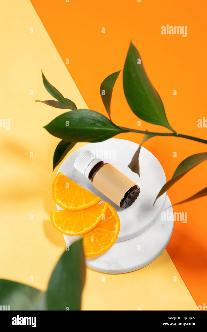Naturale organico vitamina C olio essenziale di arancia e una fetta di frutta che si posa su un fondo di mandarino. Pelle sana, effetto antistress, viso Foto Stock