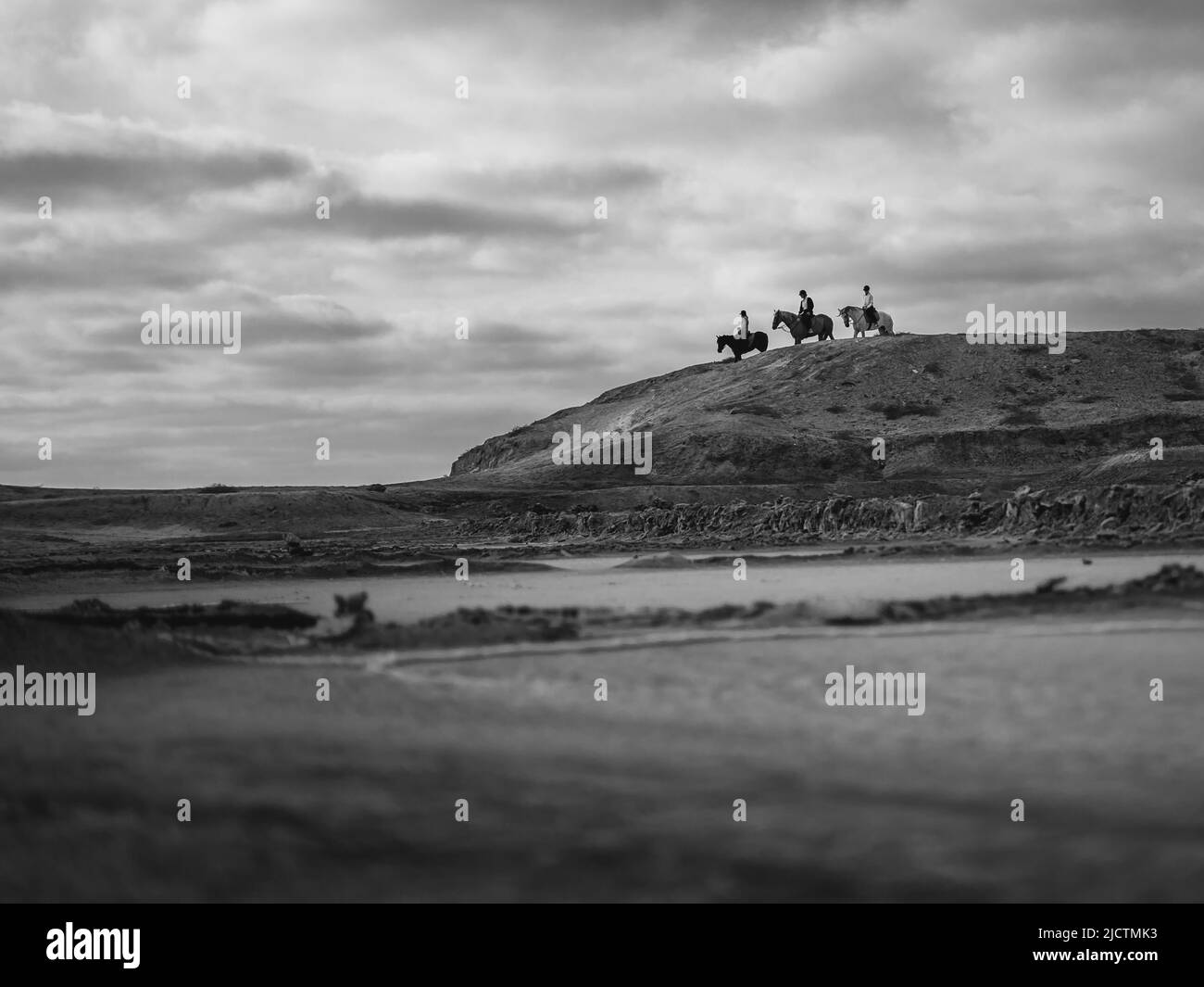 paesaggio con rocce, nuvole e cavalieri a cavallo Foto Stock