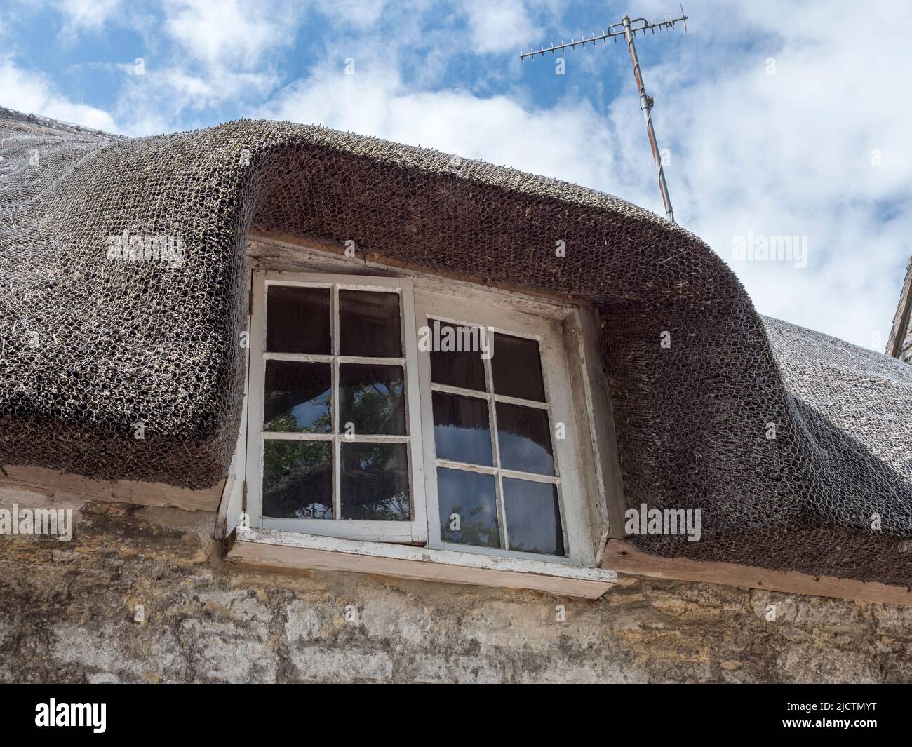 Primo piano che mostra il dettaglio del tetto di paglia intorno a una finestra del pavimento di forst a Kimmeridge, Wareham, Dorset, Regno Unito. Foto Stock