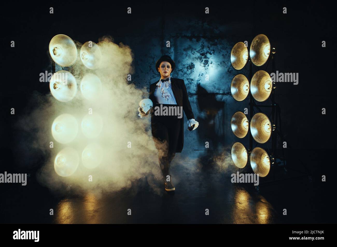 Ragazza incinta nell'immagine di un uomo grasso sullo sfondo di lampade al buio Foto Stock