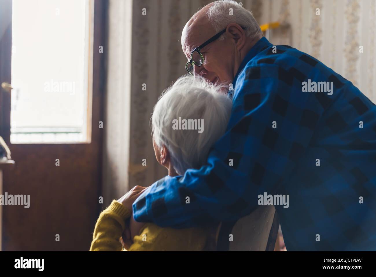 Anziano europeo coppia rilassarsi insieme a casa anziano abbracciando la sua amata moglie medio primo piano senior persone amore concetto. Foto di alta qualità Foto Stock