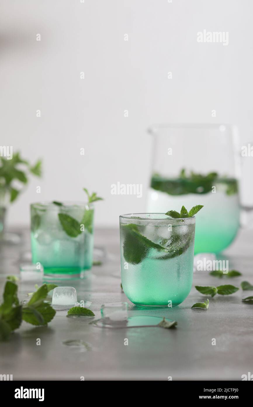 Bicchiere di acqua fredda con foglie di menta fresca e cubetti di ghiaccio Foto Stock