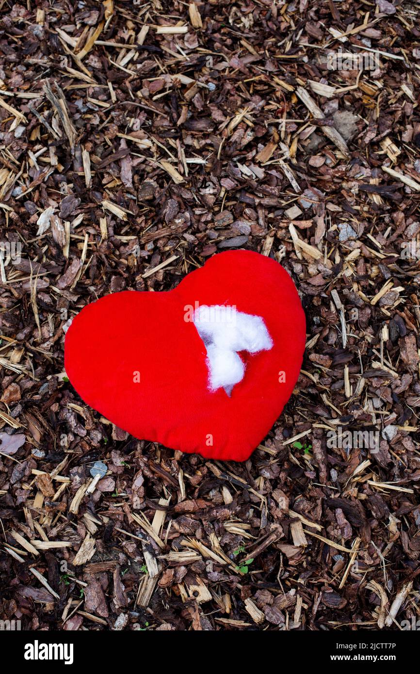 rosso strappato cuore ripieno giacente sul pavimento Foto Stock