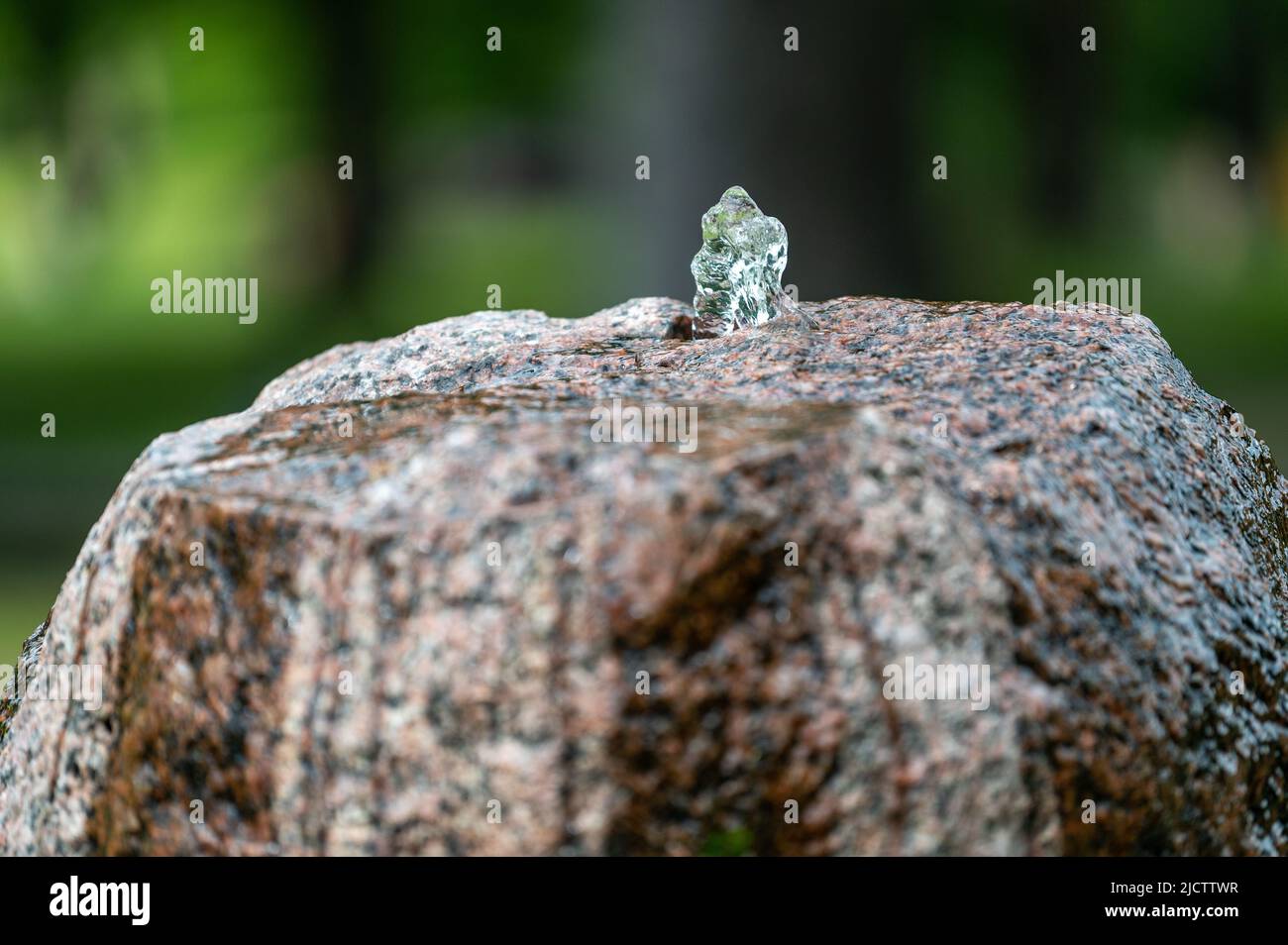 Piccola fontana da una roccia di granito in un parco a Norrkoping durante l'estate in Svezia Foto Stock