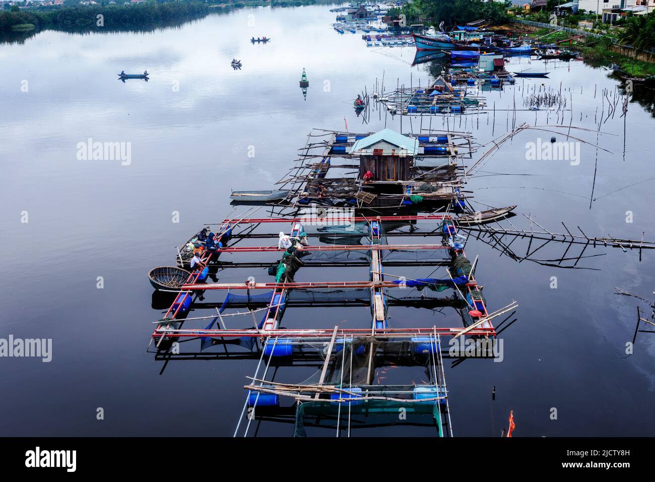 I pescatori vietnamiti costruiscono una struttura galleggiante di fattoria di pesce per catturare gamberi e piccoli pesci come le maree spostare l'acqua sul fiume Thu Bon. Foto Stock