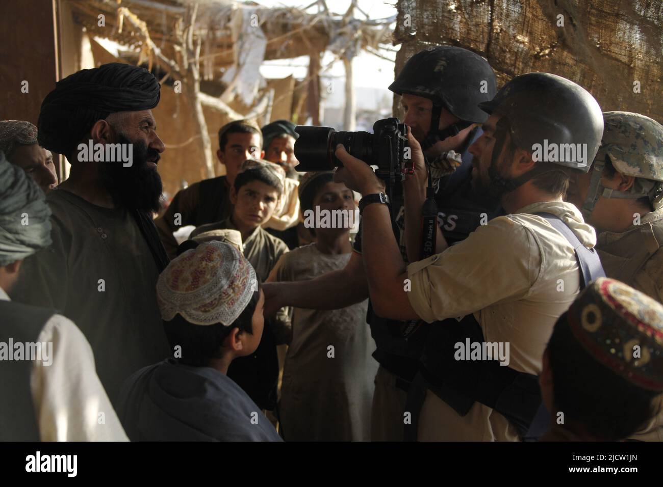 I giornalisti di al Jazeera intervistano un insegnante di una scuola locale di ragazzi a Kajaki, nella provincia di Helmond, in Afghanistan. Foto Stock