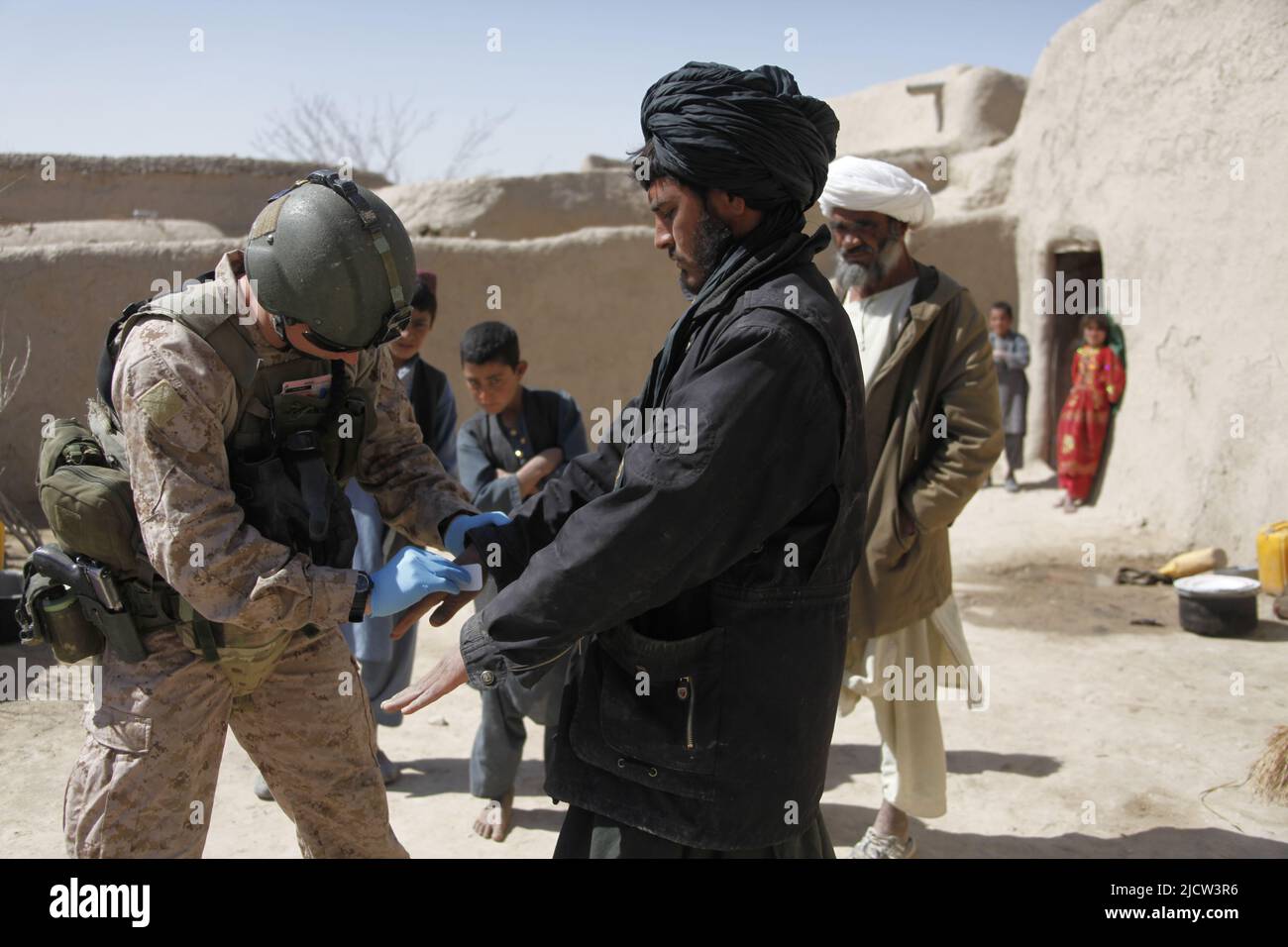 British Royal Marine Commando Lance CPL. Alan Cahill (a sinistra) pulisce le mani di un uomo afghano per verificare la presenza di sostanze chimiche e residui di colpi di pistola a Kajaki, Helm Foto Stock