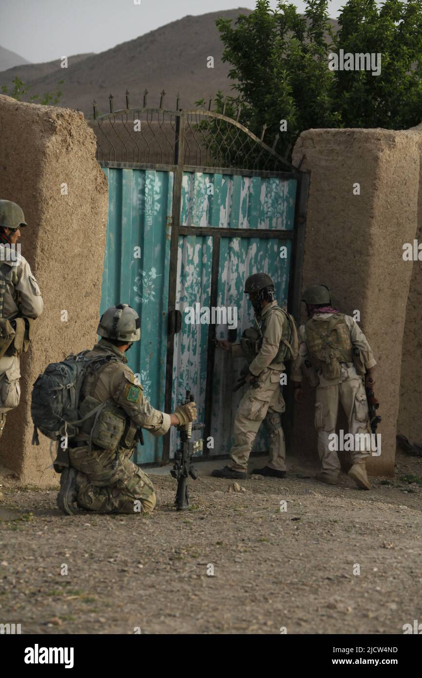 Un Royal Marine Commando britannico (a sinistra) supervisiona la sua squadra di tigri afghane entrando in un composto a Keshwar, provincia di Helmand, Afghanistan 18 aprile 2012. Th Foto Stock