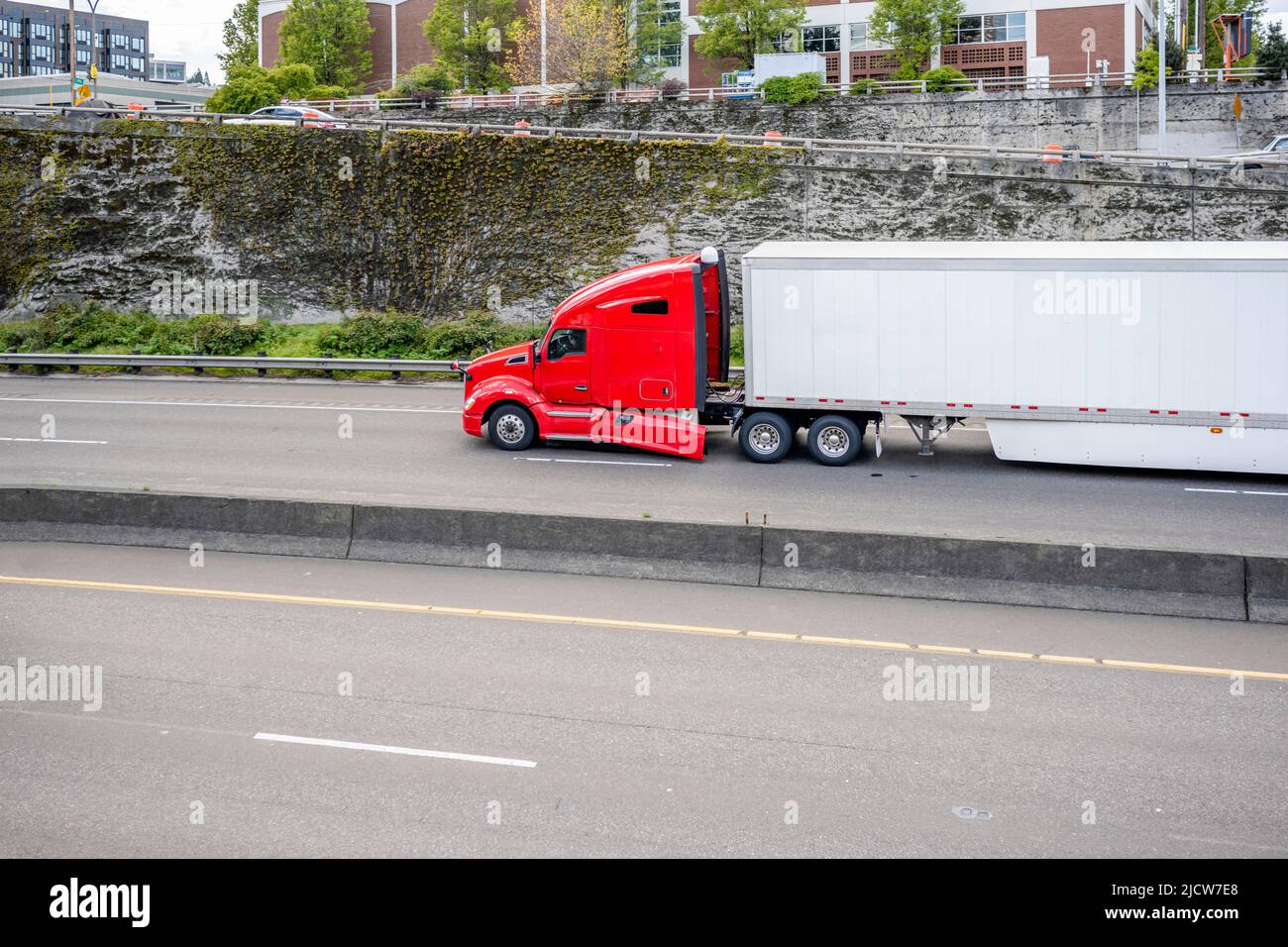 Trattore semirimorchio rosso industriale con carro grande e carico classico con parafango rotto per il trasporto di carichi commerciali in semirimorchio a secco per la consegna Foto Stock