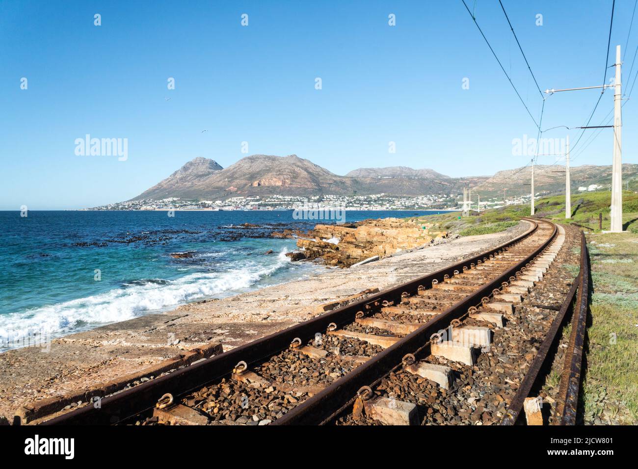 Linea ferroviaria o binari ferroviari paralleli al mare o all'oceano e diretti verso la città di Simon, Capo Occidentale, Sud Africa Foto Stock