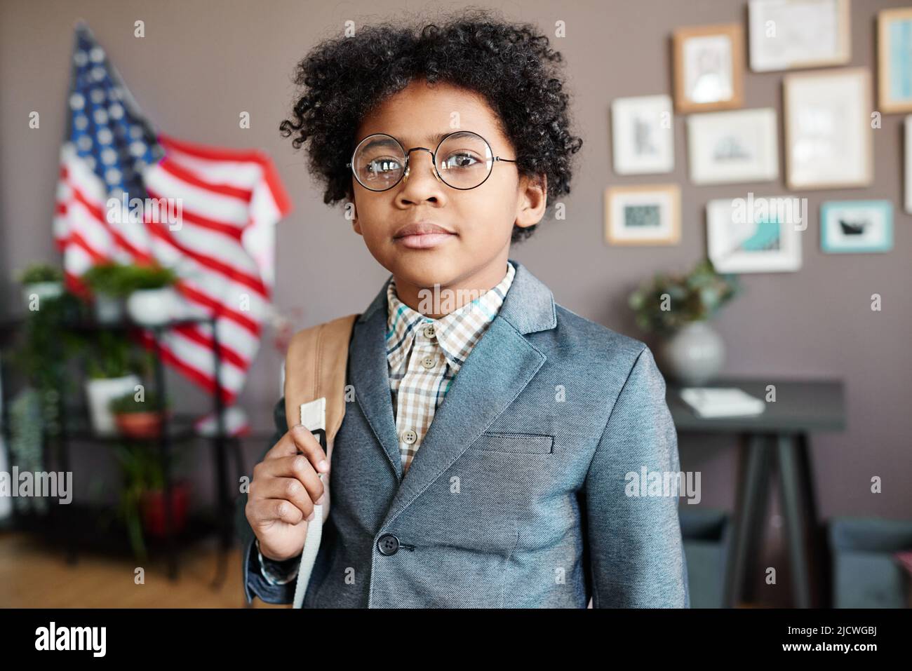 Ritratto di scolaro africano in occhiali e uniforme in piedi con zaino pronto per andare a scuola Foto Stock