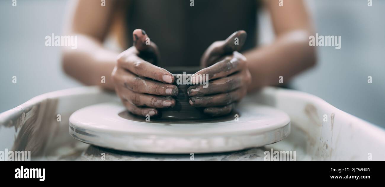 Le mani della donna si avvicinano, il magistrale studio di ceramica lavora con argilla sulla ruota di un vasaio. Foto Stock