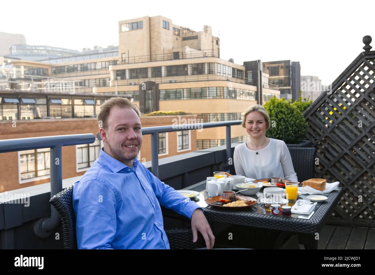 La coppia ha fatto colazione su una terrazza sul tetto nella grande città Foto Stock