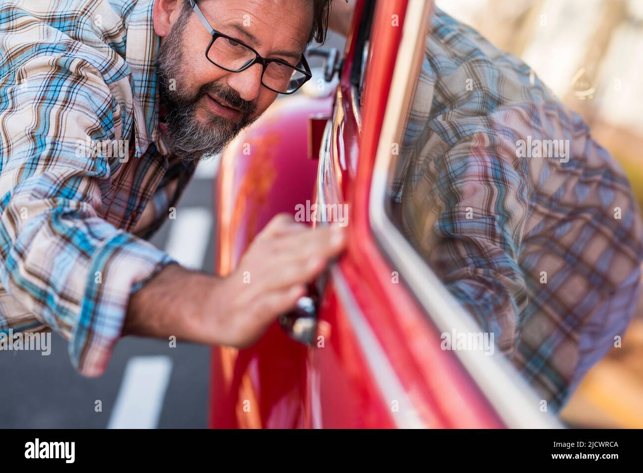 Primo piano di un uomo che ha la sua auto nuova. Concetto di amanti del veicolo con uomini che controllano lucido e lucidante - proprietario o meccanico con automobile . Tra Foto Stock