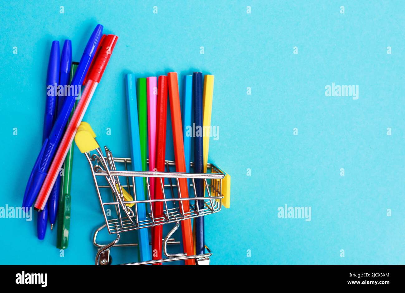 carrello con matite colorate su sfondo blu Foto Stock