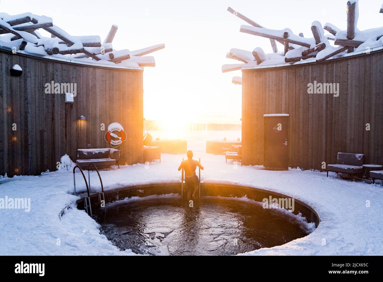 Uomo che si gode il tramonto mentre si prende un bagno freddo nella piscina dell'Arctic Bath Spa and Wellness Hotel, Harads, Lapponia, Svezia, Scandinavia, Europa Foto Stock