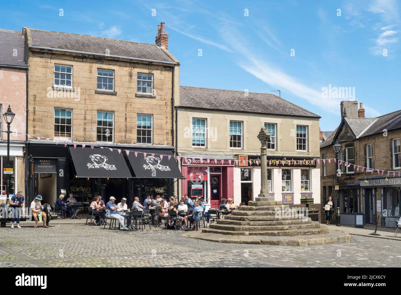 Persone che siedono all'esterno di un caffè in Alnwick Market Square, Northumberland, Inghilterra, Regno Unito Foto Stock