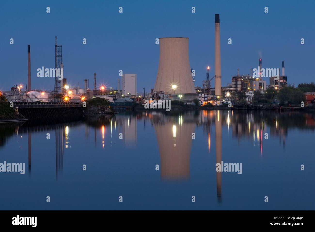 La raffineria di Stanlow Oil si riflette nel canale della nave di Manchester di notte, vicino al porto di Ellesmere, Cheshire, Inghilterra, Regno Unito, Europa Foto Stock