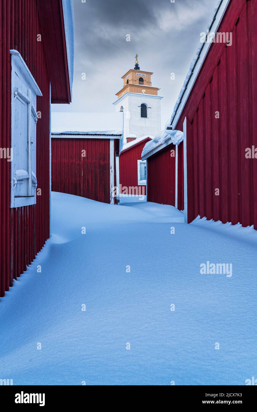 Nuvole sopra le case rosse coperte di neve e il campanile, Gammelstad Church Town, Patrimonio dell'Umanità dell'UNESCO, Lulea, Svezia, Scandinavia, Europa Foto Stock