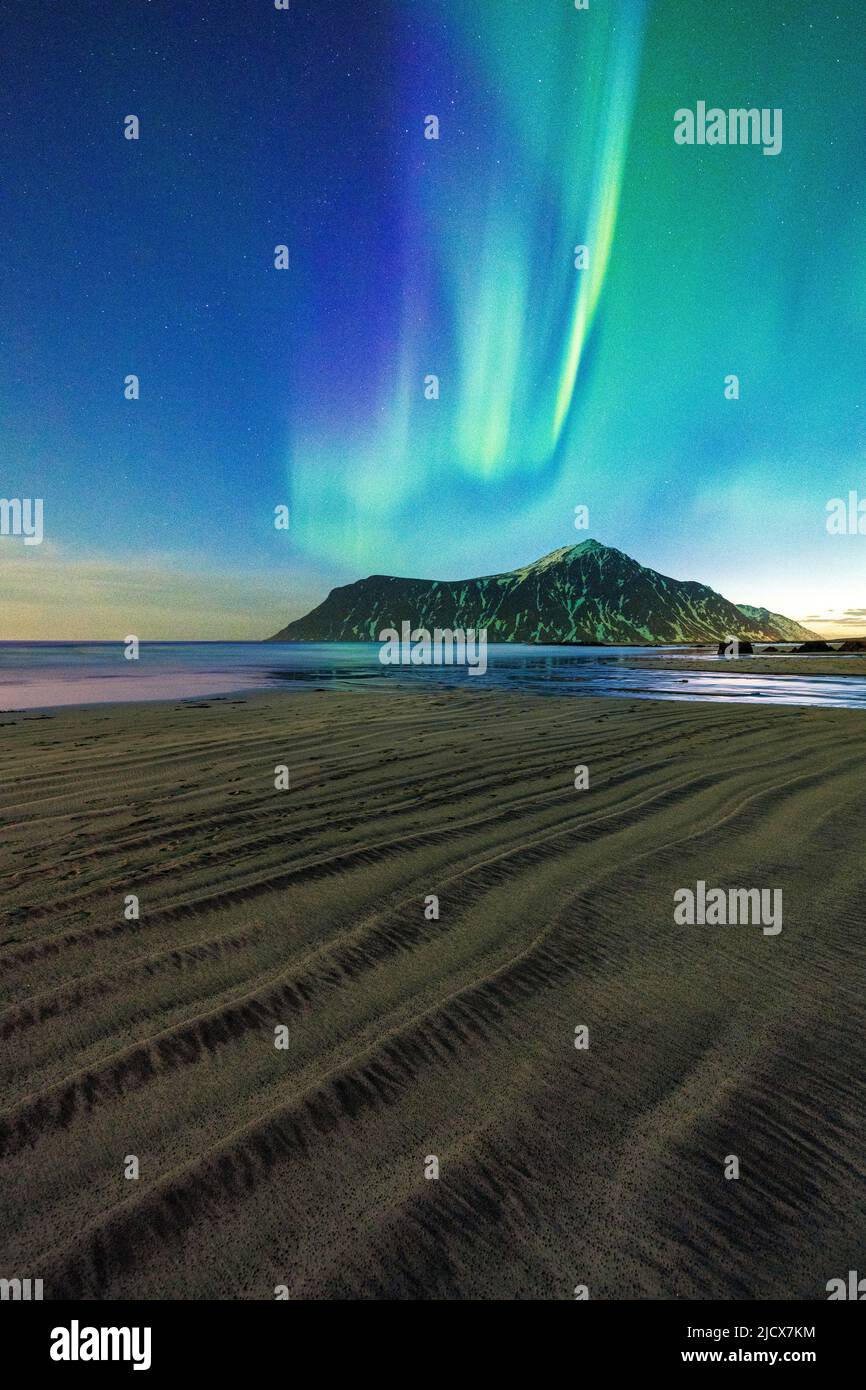 Sabbia ruvida della spiaggia di Skagsanden illuminata da luci verdi di Aurora Borealis (aurora boreale), Flakstad, Isole Lofoten, Norvegia, Scandinavia, Europa Foto Stock