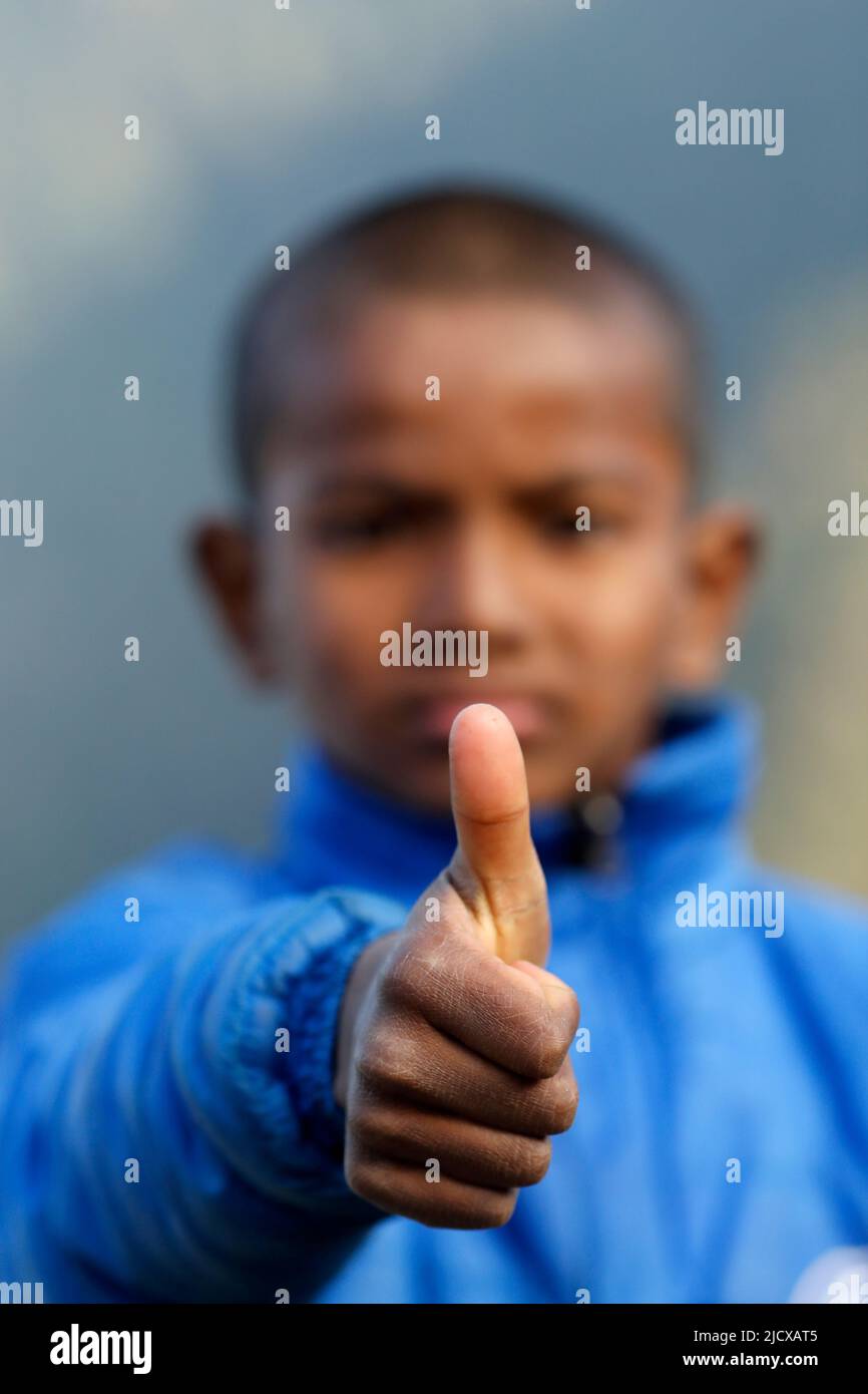 Centro di riabilitazione per bambini di strada, ritratto di ragazzo dando i pollici in su, segno positivo di accordo e simili, Nepal, Asia Foto Stock