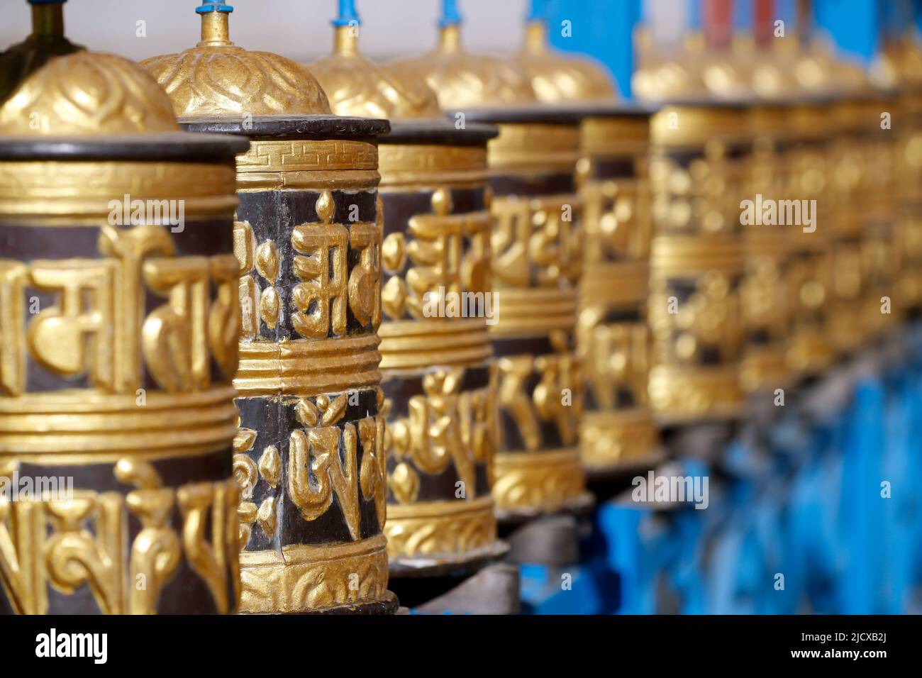 Ruote di preghiera in metallo rotolante che girano intorno, con mantra scritto in lingua tibetana, monastero buddista di Shakhya Tharig, Kathmandu, Nepal, Asia Foto Stock