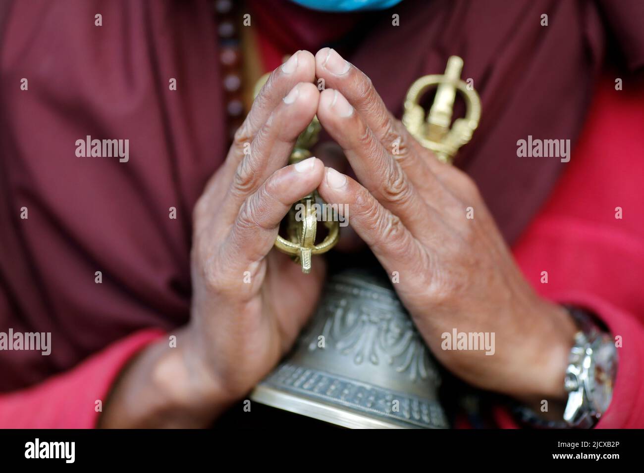 Monaco buddista (lama) in abiti tradizionali che detengono attributi rituali di buddismo, rosario, vajra, campana, monastero di Pema Osel Ling, Kathmandu, Nepal, Asia Foto Stock